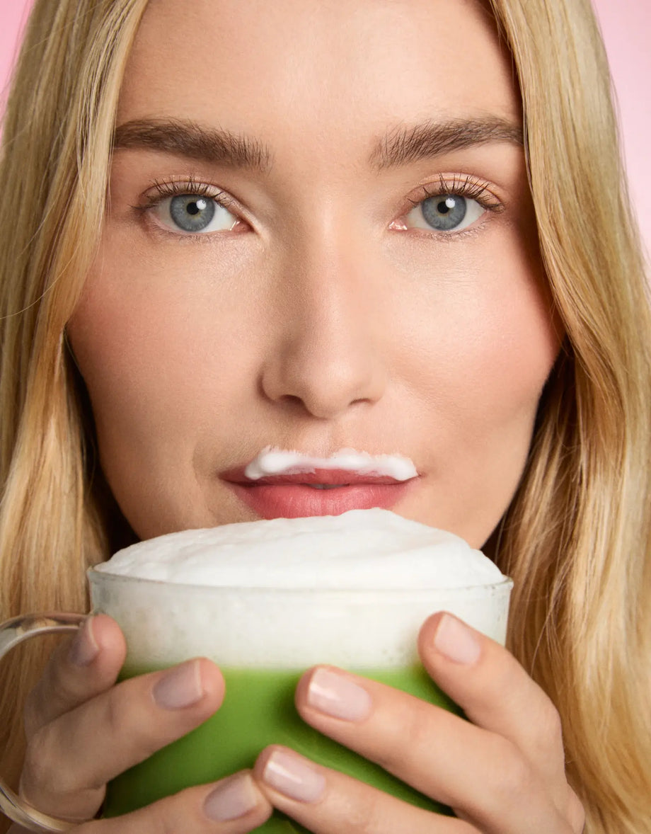 Femme bois une tasse matcha latte mousse de lait